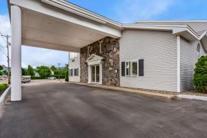 a large white building with a garage at Quality Inn & Suites Gorham Riverside in Gorham