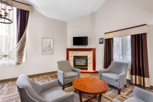 a living room with chairs and a table and a fireplace at Quality Inn & Suites Gorham Riverside in Gorham