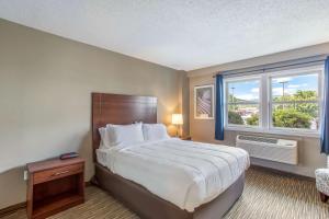a bedroom with a large bed and a window at Quality Inn & Suites Gorham Riverside in Gorham
