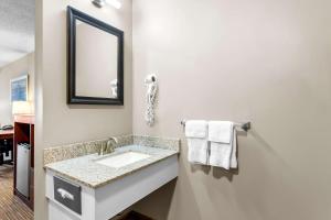 a bathroom with a sink and a mirror and towels at Quality Inn & Suites Gorham Riverside in Gorham