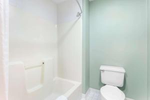 a white bathroom with a toilet and a shower at Quality Inn & Suites Gorham Riverside in Gorham