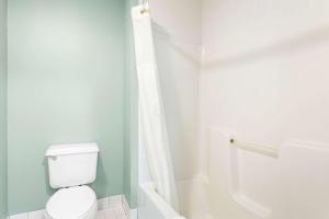 a white bathroom with a toilet and a shower at Quality Inn & Suites Gorham Riverside in Gorham