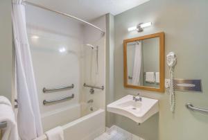 a white bathroom with a sink and a shower at Quality Inn & Suites Gorham Riverside in Gorham