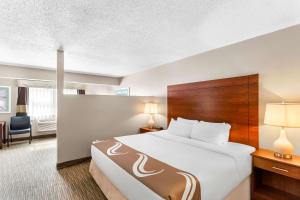 a hotel room with a bed and a desk at Quality Inn & Suites Gorham Riverside in Gorham