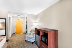 a room with a tv and a chair in a hotel room at Quality Inn & Suites Gorham Riverside in Gorham