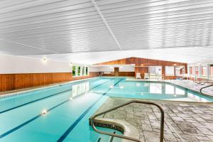 a large indoor swimming pool with blue water at Quality Inn & Suites Gorham Riverside in Gorham