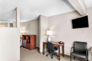 a room with a desk and two chairs and a television at Quality Inn & Suites Gorham Riverside in Gorham