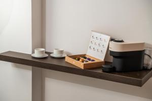 a shelf with a coffee maker and a box of donuts at Ypnos Rooms in Naples