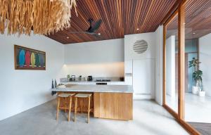 a kitchen with a wooden ceiling and a counter with stools at Amazing 3BDR-Villa Canggu/Seseh 2min walk to Beach in Canggu