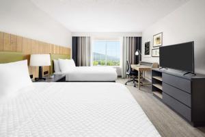 a hotel room with a bed and a desk with a tv at Country Inn & Suites by Radisson, Big Flats (Elmira), NY in Horseheads