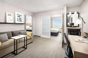 a living room with a couch and a bed at Country Inn & Suites by Radisson, Big Flats (Elmira), NY in Horseheads