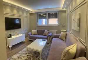 a living room with a couch and a tv at Merdan Sarajevo in Sarajevo