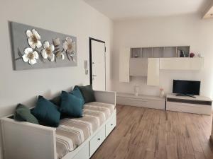 a white living room with a couch and a television at CARLA' S HOUSE in Anzola dell'Emilia