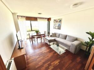 a living room with a couch and a table at BaruHaus piscina y parking Rianxo 1 in Rianjo