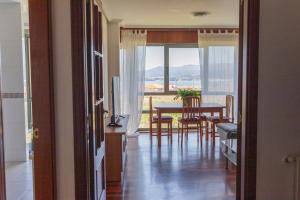 a room with a table and a dining room with a view at BaruHaus piscina y parking Rianxo 1 in Rianjo