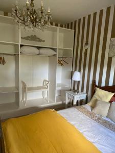 een slaapkamer met een bed en een kroonluchter bij L’hirondelle du Faubourg in Saudemont +101 foto's
