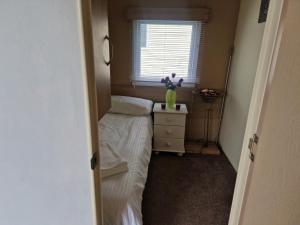 Un dormitorio pequeño con una cama y una ventana. en Lodge Sleeps 4 - Pet Friendly with Private Parking, en Barnstaple