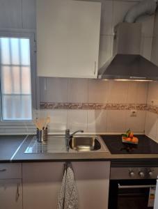 eine Küche mit weißen Schränken und einer Spüle und einem Fenster in der Unterkunft Torete in Roquetas de Mar + 4 Fotos