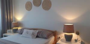 a bedroom with a bed with two lamps on it at Sunshine Apartment in Bijeljina