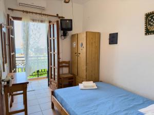 a bedroom with a bed and a desk and a television at ΑΡΜΕΝΙΣΤΗΣ House for your vacation in Armenistis
