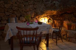 a table with candles and chairs in a stone room at Apartments Villa Ypsilon in Sveta Nedelja
