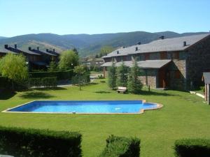 a swimming pool in a yard next to a house at Casa adosada con piscina en Palau de Cerdanya in Palau-de-Cerdagne