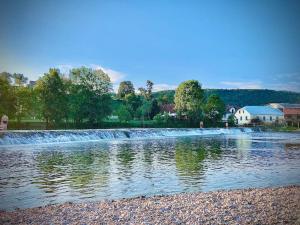 um rio com uma pequena cachoeira em uma cidade em Apartma Laganini em Bosiljevo