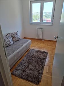a living room with a couch and a window at Vels Suite - Cozy Oasis & Free Parking in Voždivac