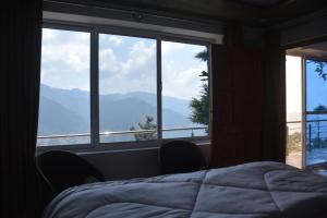 1 dormitorio con cama y vistas a las montañas en Mountain View Guest House by LMC, en Nathia Gali