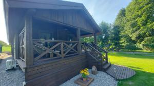 a small building with a porch and a vase of flowers at Domek Izdebska chata in Izdebno