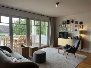 a living room with a couch and a chair and a television at Ferienwohnung Mühlbach in Breitbrunn am Chiemsee