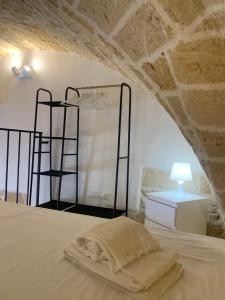 a bed in a room with a stone wall at Le Dimore del Castello in Nardò