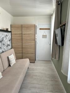 Una sala de estar con un sofá y una puerta. en Le Chanzy Proche des Thermes et de la Gare, en Rochefort