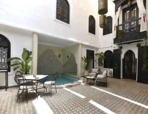 um pátio com uma mesa e cadeiras num edifício em Riad Zoraida em Marraquexe