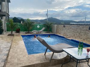 a woman is swimming in a swimming pool at VillaLunaCaridad in Jarabacoa