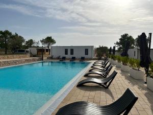 a row of chairs sitting next to a swimming pool at Holiday Home Ahil 10 in Pakoštane