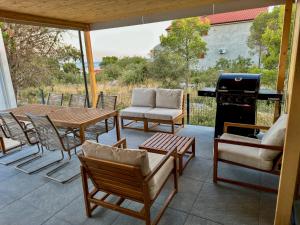 a patio with a table and chairs and a grill at Holiday Home Ahil 10 in Pakoštane