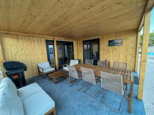 a porch with a wooden table and chairs and a stove at Holiday Home Ahil 10 in Pakoštane