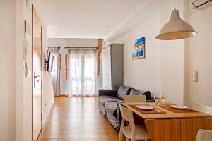 a living room with a couch and a table in a room at Apartamento con terraza privada cerca de la playa in Valencia