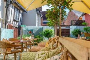 an outdoor seating area with tables and chairs at The Great House Lavenham Hotel & Restaurant in Lavenham