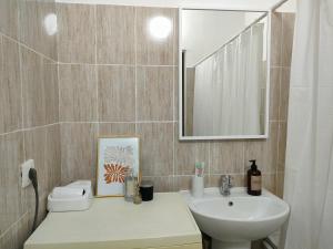 a bathroom with a sink and a mirror at ЖК Шугыла Apartment in Shugyla +28 photos