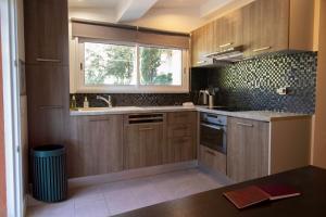 a kitchen with wooden cabinets and a window at Athéna MOTEL in Saint-Aygulf