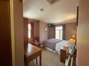 ハンティンドンにあるThe Prince of Walesのベッドと机と机があるホテルの部屋 +18枚の写真