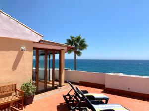 a patio with chairs and a view of the ocean at Penthouse on the beachfront in Estepona +23 photos