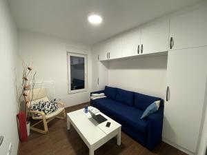 a living room with a blue couch and a table at LadyDi apartman in Banja Koviljača