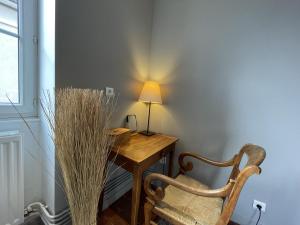 a room with a desk with a lamp and a chair at La Maison du Chablisien in Chablis