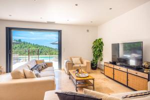 a living room with a couch and a tv at Villa Mas des Lavandes by Villa Plus in Le Tignet