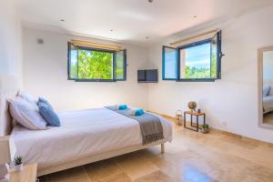 a bedroom with a bed and three windows at Villa Mas des Lavandes by Villa Plus in Le Tignet +20 photos
