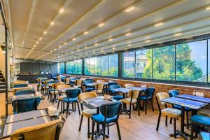 a restaurant with tables and chairs and large windows at Sultan Hamit Hotel in Istanbul