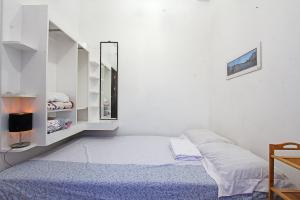 ein weißes Zimmer mit einem Bett und einem Spiegel in der Unterkunft Jmt star's inn in General Luna